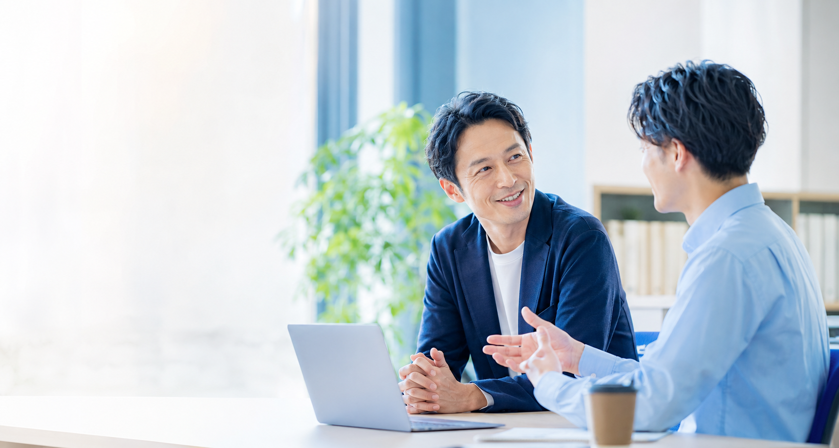 部下の話に笑顔で耳を傾ける40代管理職の1on1ミーティング